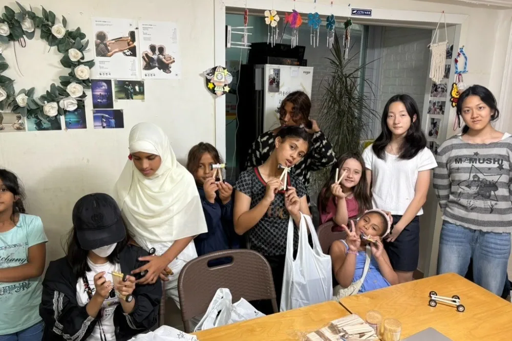 Students holding the cars they built at a GEMS workshop